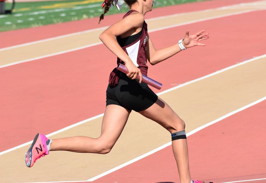 Atleta juvenil corriendo un relevo en pista