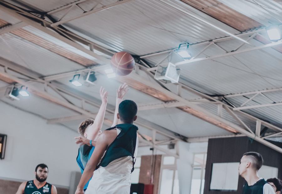 Partido de básquetbol en un gimnasio con estructura de metal