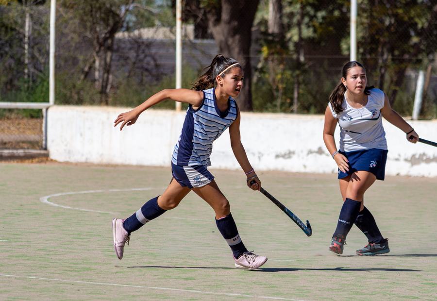 Jugadoras juveniles de hockey césped disputando el balón