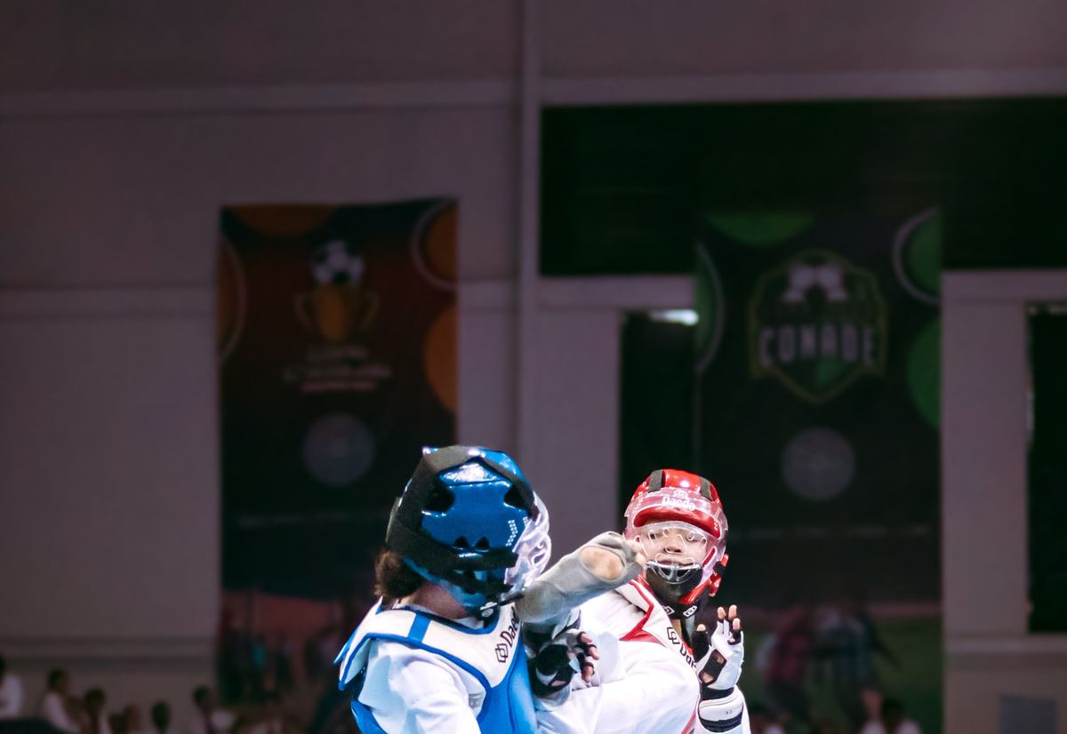 Competencia de taekwondo entre dos deportistas juveniles con protecciones