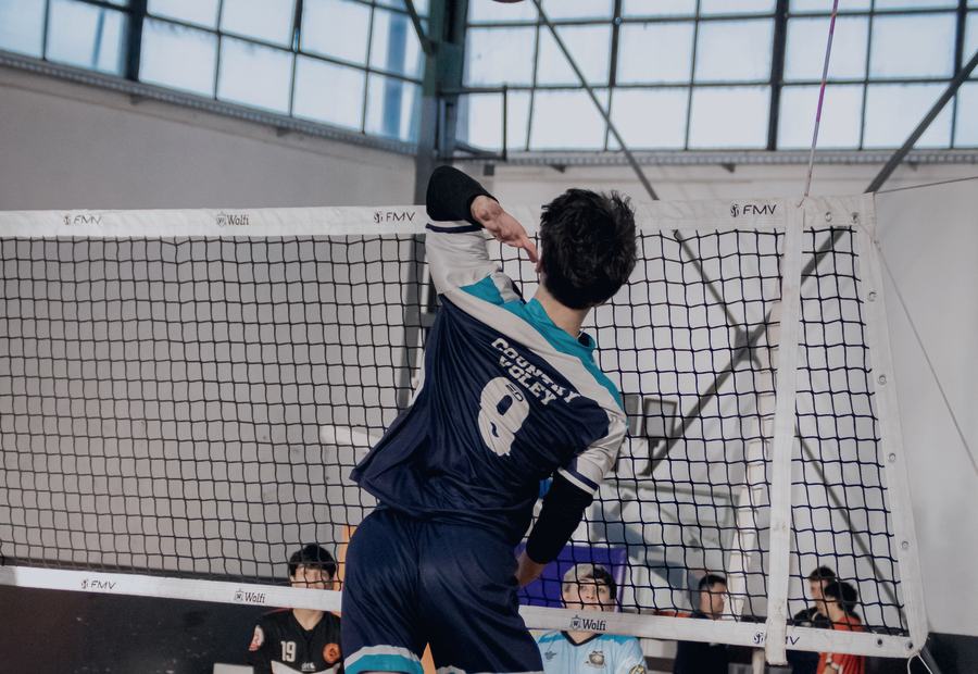 Jugador de vóleibol saltando para rematar en un gimnasio